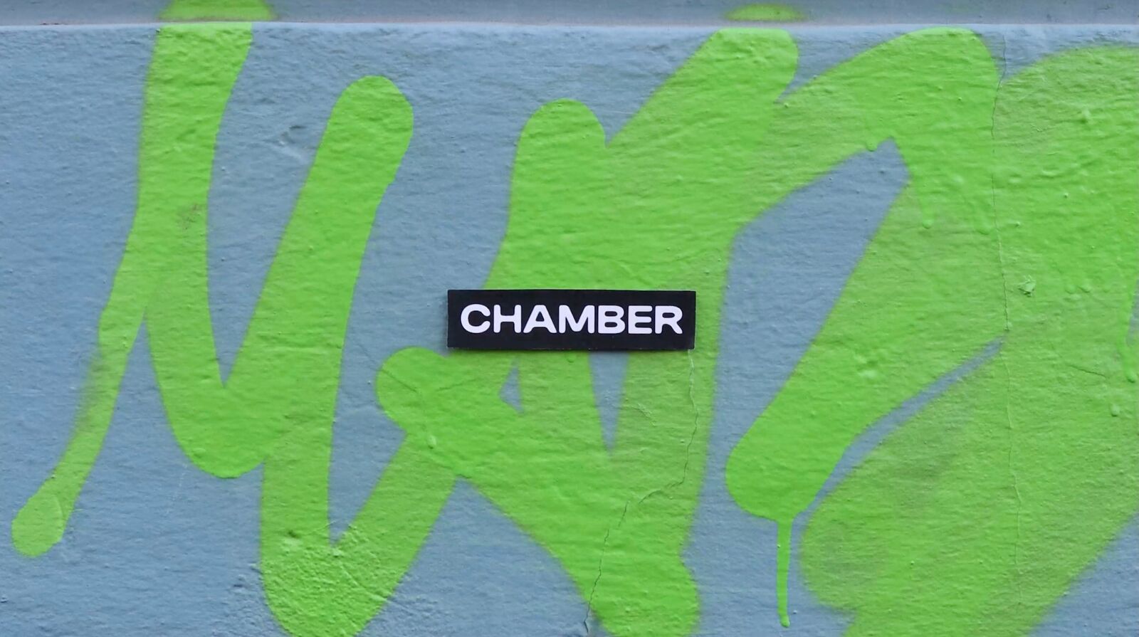 Chamber-klistremerke på grønn graffiti