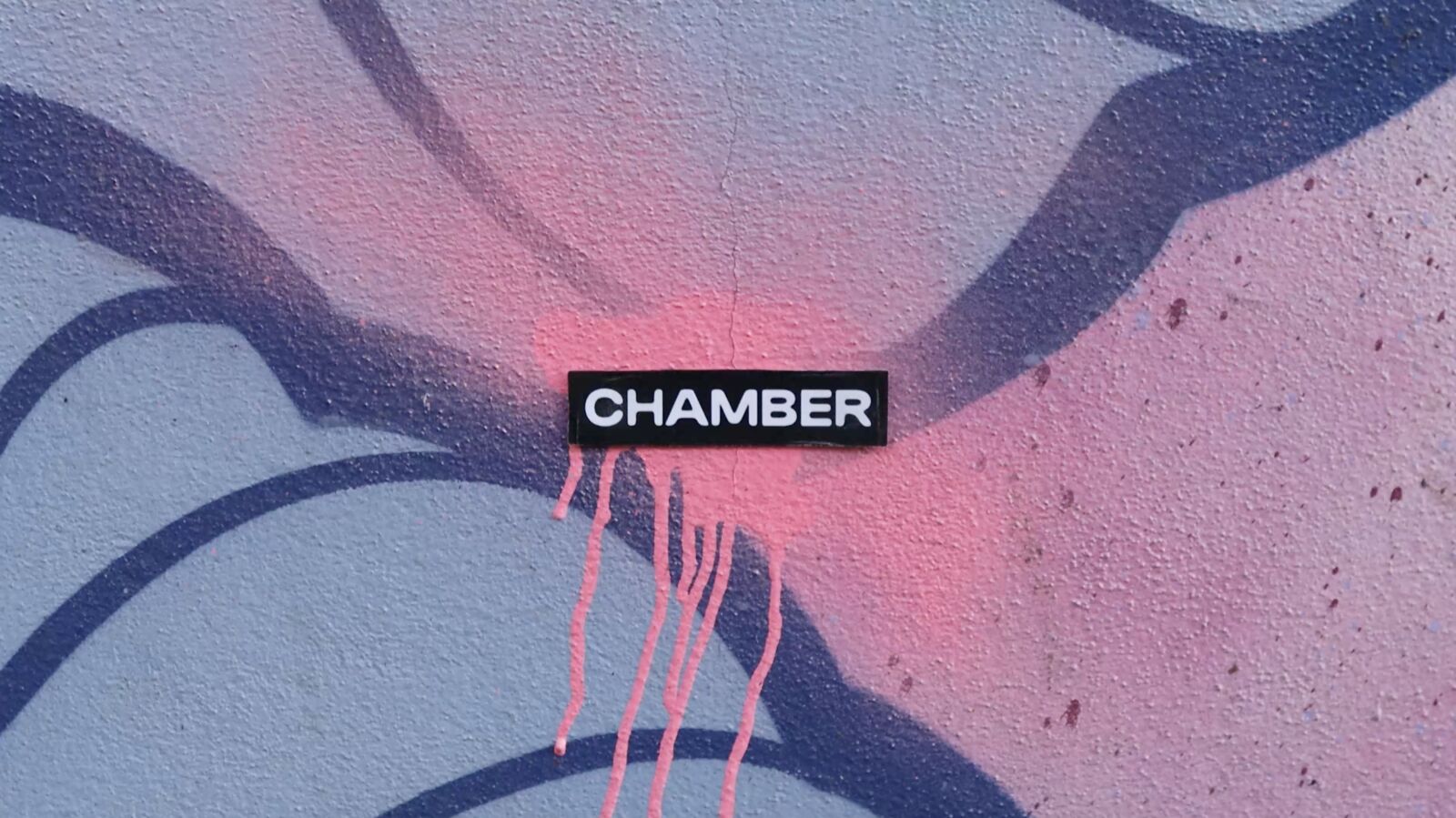 Chamber-klistremerke på rosa og blå graffiti med rennende maling